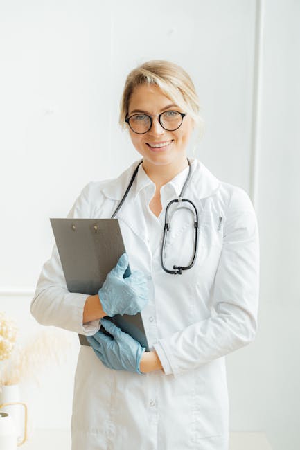 Portrait of a smiling female doctor in a lab coat with stethoscope and clipboard indoors.